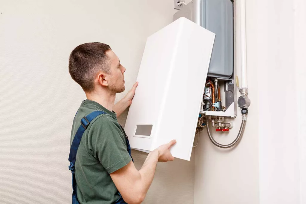 A plumber fitting a boiler