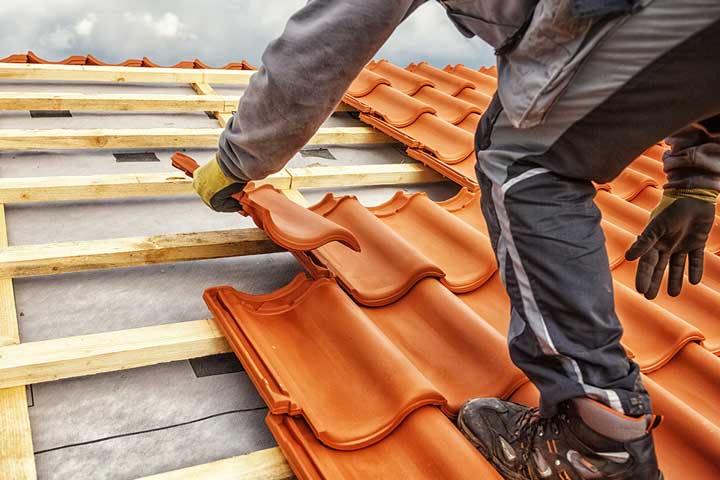 a man fitting roof tiles on a new roof installation